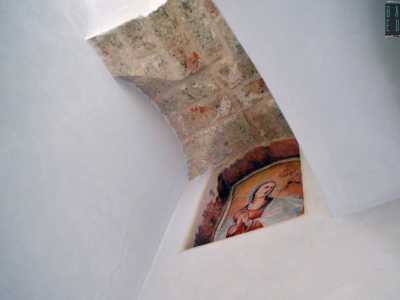 Accanto al frate vi � poi l�immagine dai colori tenui di un volto femminile addolorato, quello della Madonna in preghiera